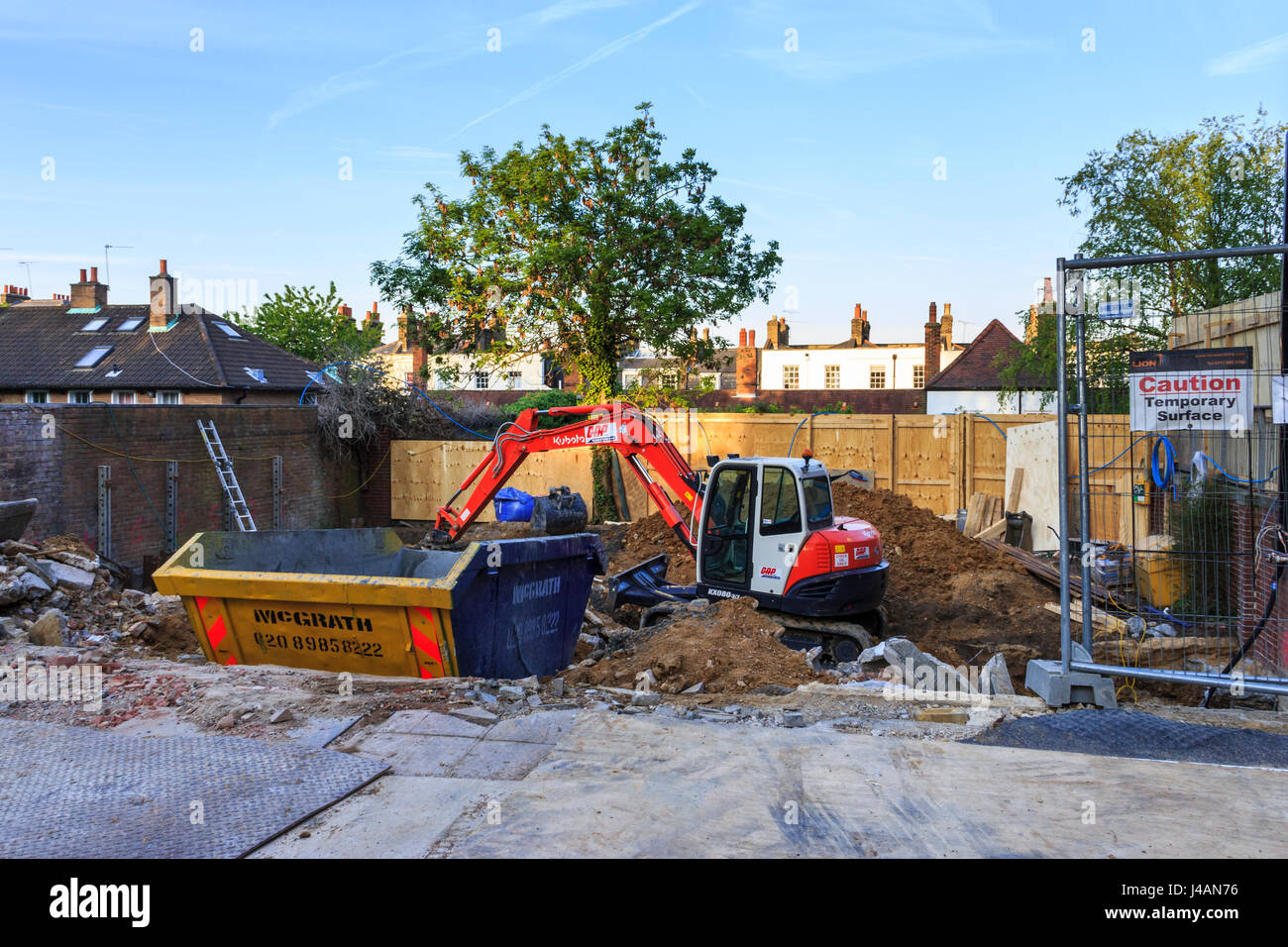 Eine mechanische Digger und ein Überspringen auf einer Baustelle in, London, UK Stockfoto