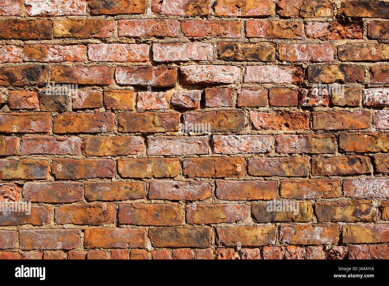 eine alte verwitterte Ziegel Wand Hintergrund mit im Alter von Zement und bunten alten Ziegelsteinen Stockfoto
