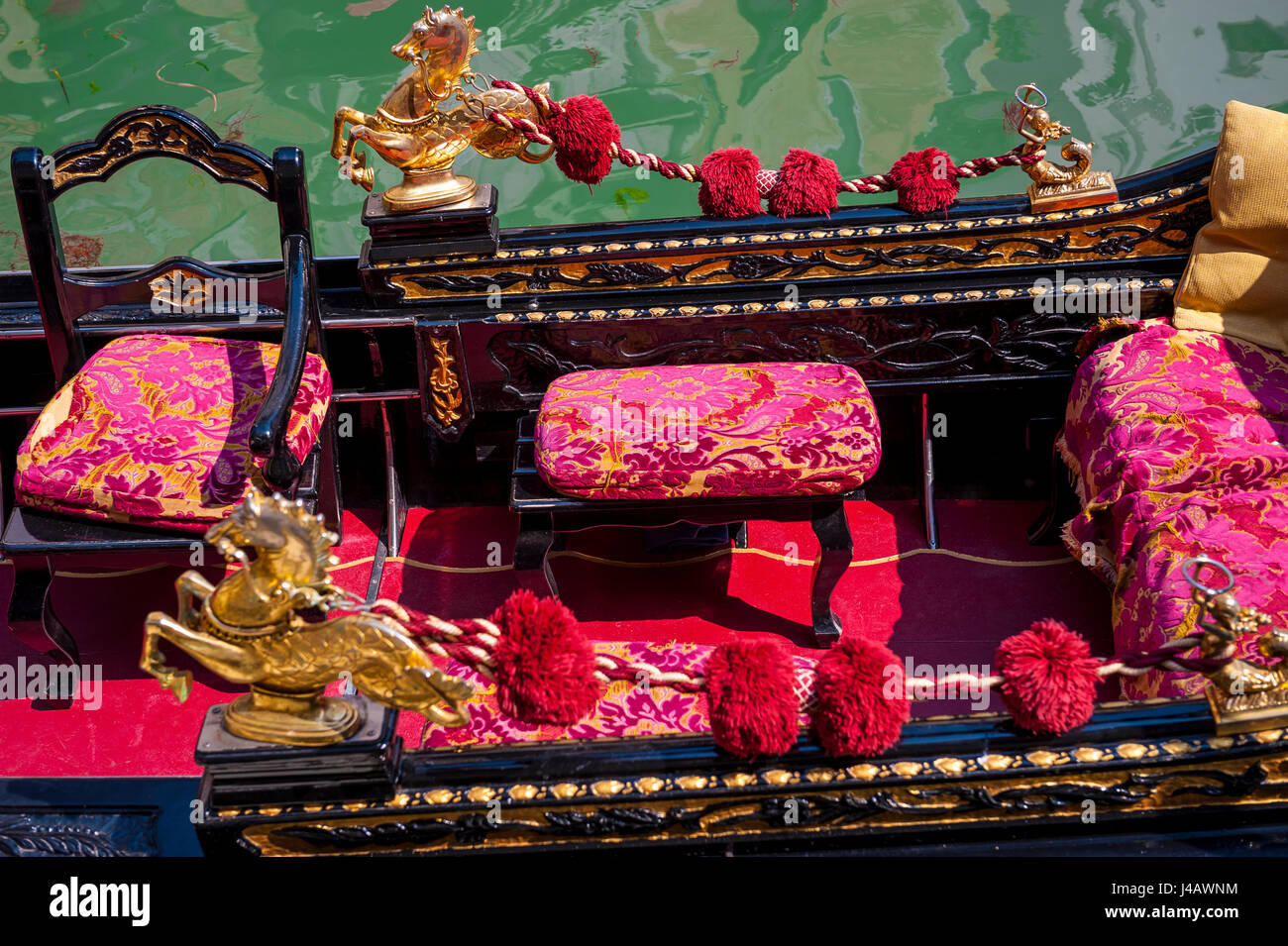 Nahaufnahme Detail der traditionellen venezianischen Gondel mit dekorativen Plüsch rot Sitzgelegenheiten warten auf Kunden an einem Kanal in Venedig, Italien Stockfoto