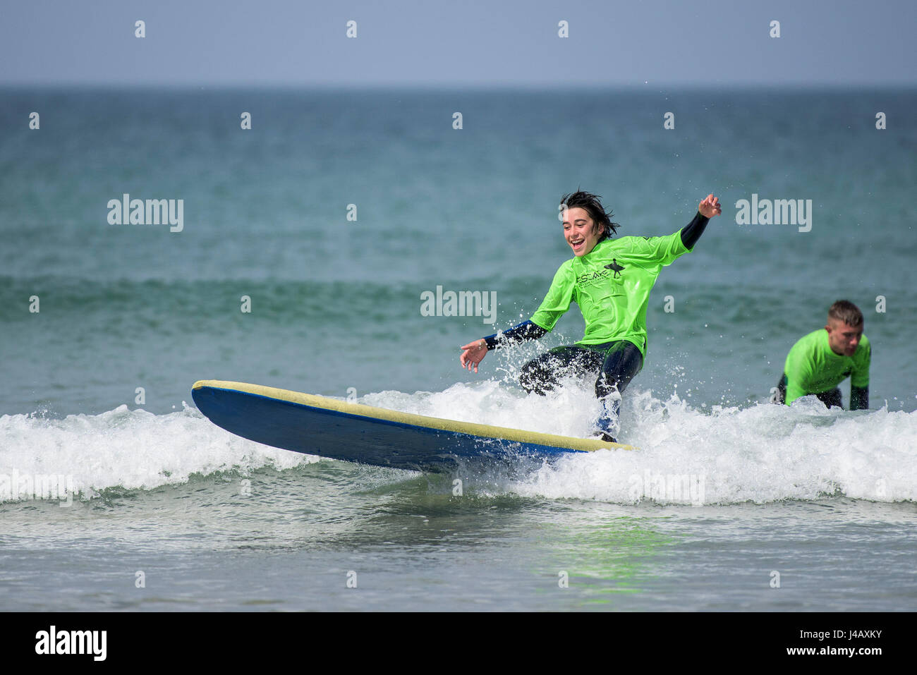 Anfänger lernen Surfen auf den Fistral Beach in Newquay Cornwall Escape Surf School Surfen Surfer Lernende Lernen am Meer Meer Tourismus zu Stockfoto