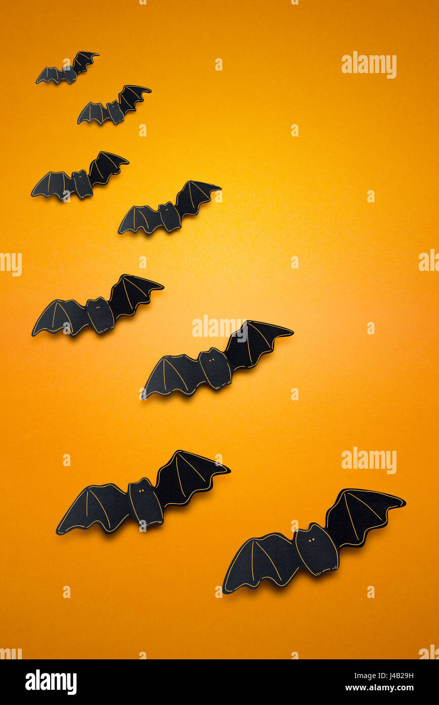 Kreative Halloween Konzept Foto von Fledermäusen Papier auf orangem Hintergrund. Stockfoto
