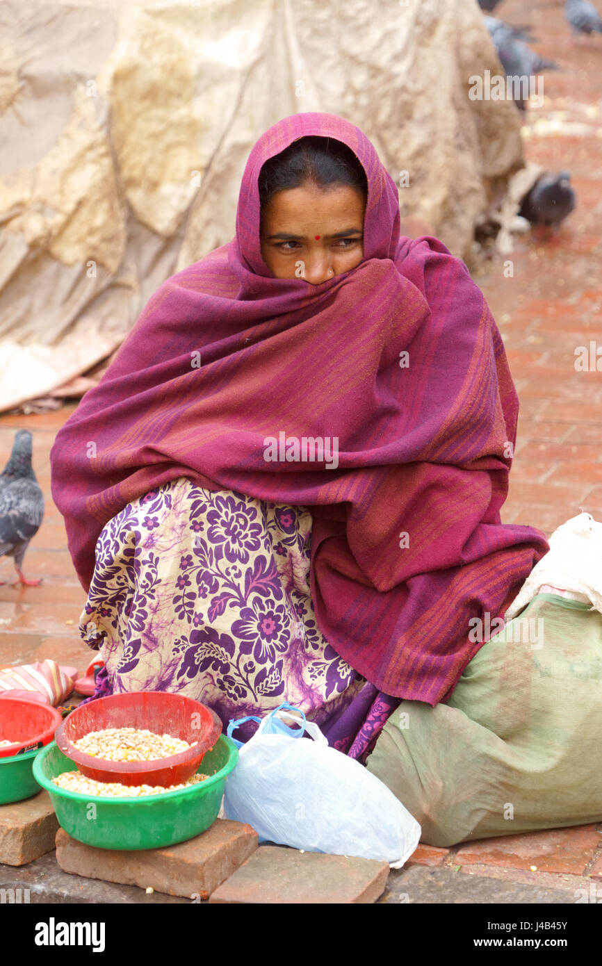 Nepalesische Frau verkaufen Mais die Tauben am Durbar Square, Kathmandu. Stockfoto