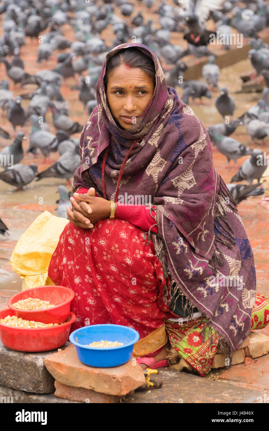 Nepalesische Frau verkaufen Mais die Tauben am Durbar Square, Kathmandu. Stockfoto
