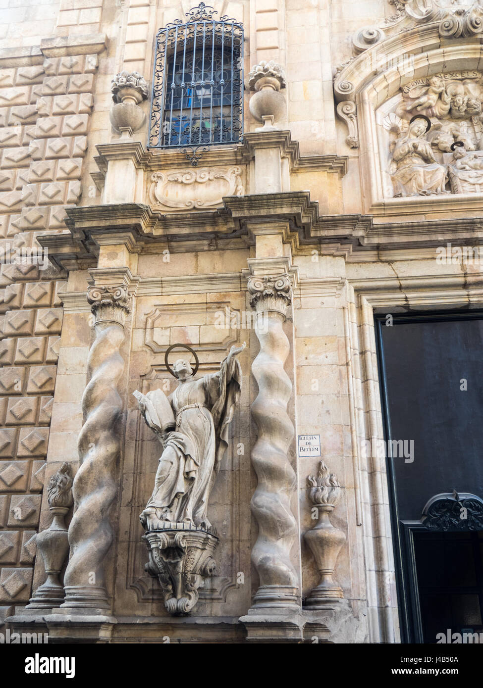 Statue der Jesuit Ignatius von Loyola, eingerahmt von zwei salomonischen Säulen am Eingang der Bethlehem-Kirche in Barcelona. Stockfoto