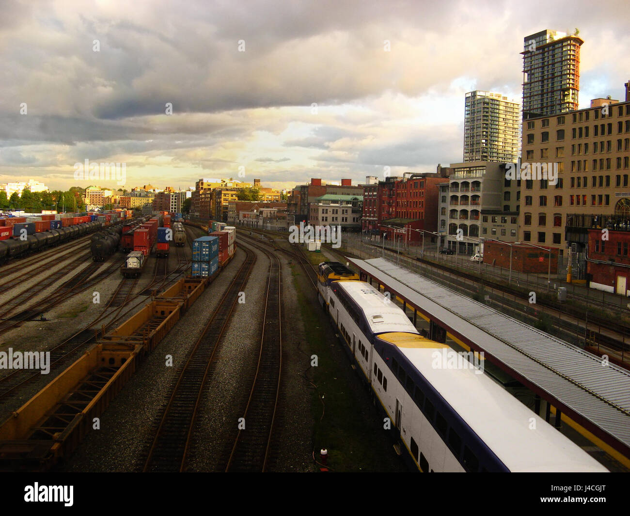 Skyline von East Vancouver mit pendeln Züge auf Eisenbahn und bewölkten Himmel bei Sonnenaufgang Stockfoto