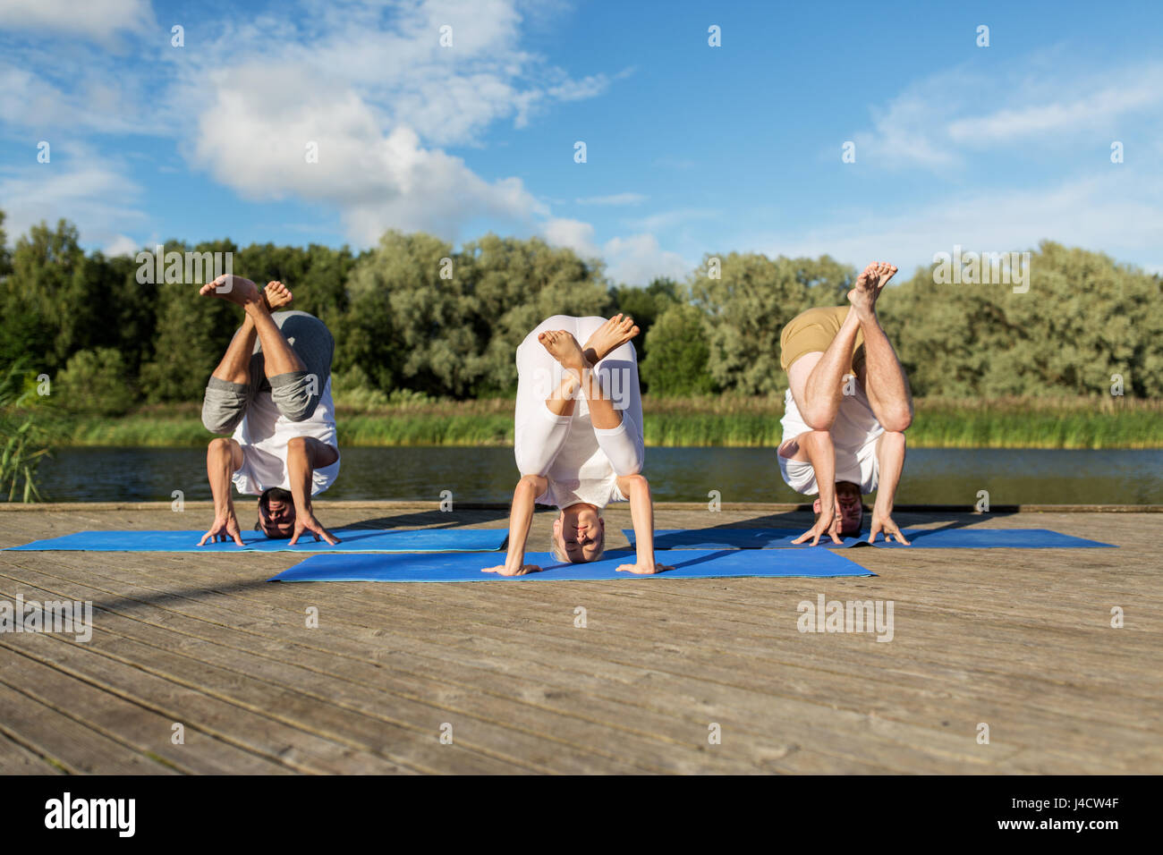 Menschen, die Yoga im Kran-Pose im freien Stockfoto