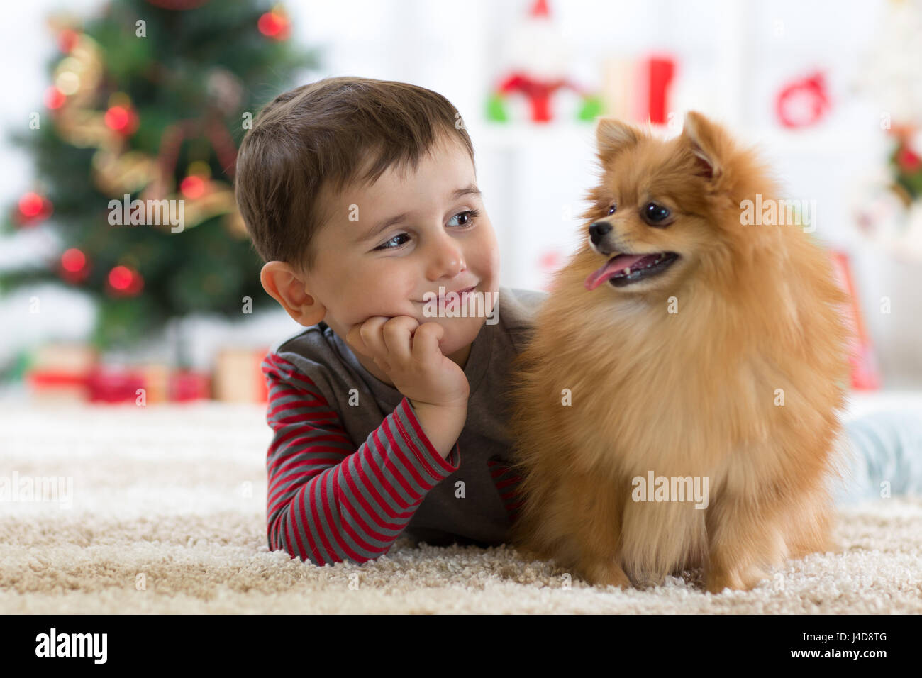 Wenig Kind Junge mit Hund auf dem Boden liegend in Festsaal Stockfoto
