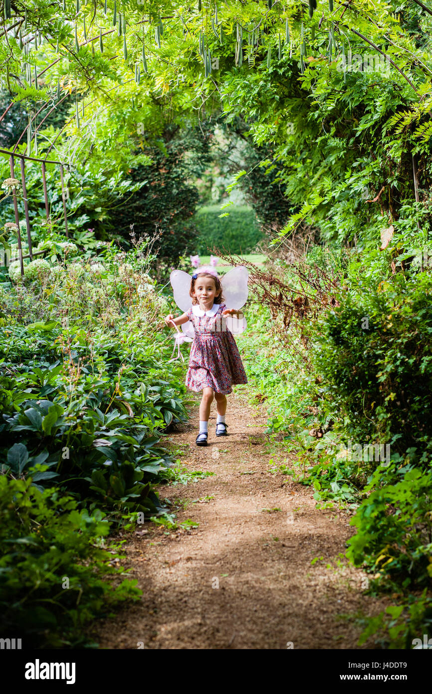 Dressing up - eine Mädchen spielt als eine Fee im englischen Garten Stockfoto