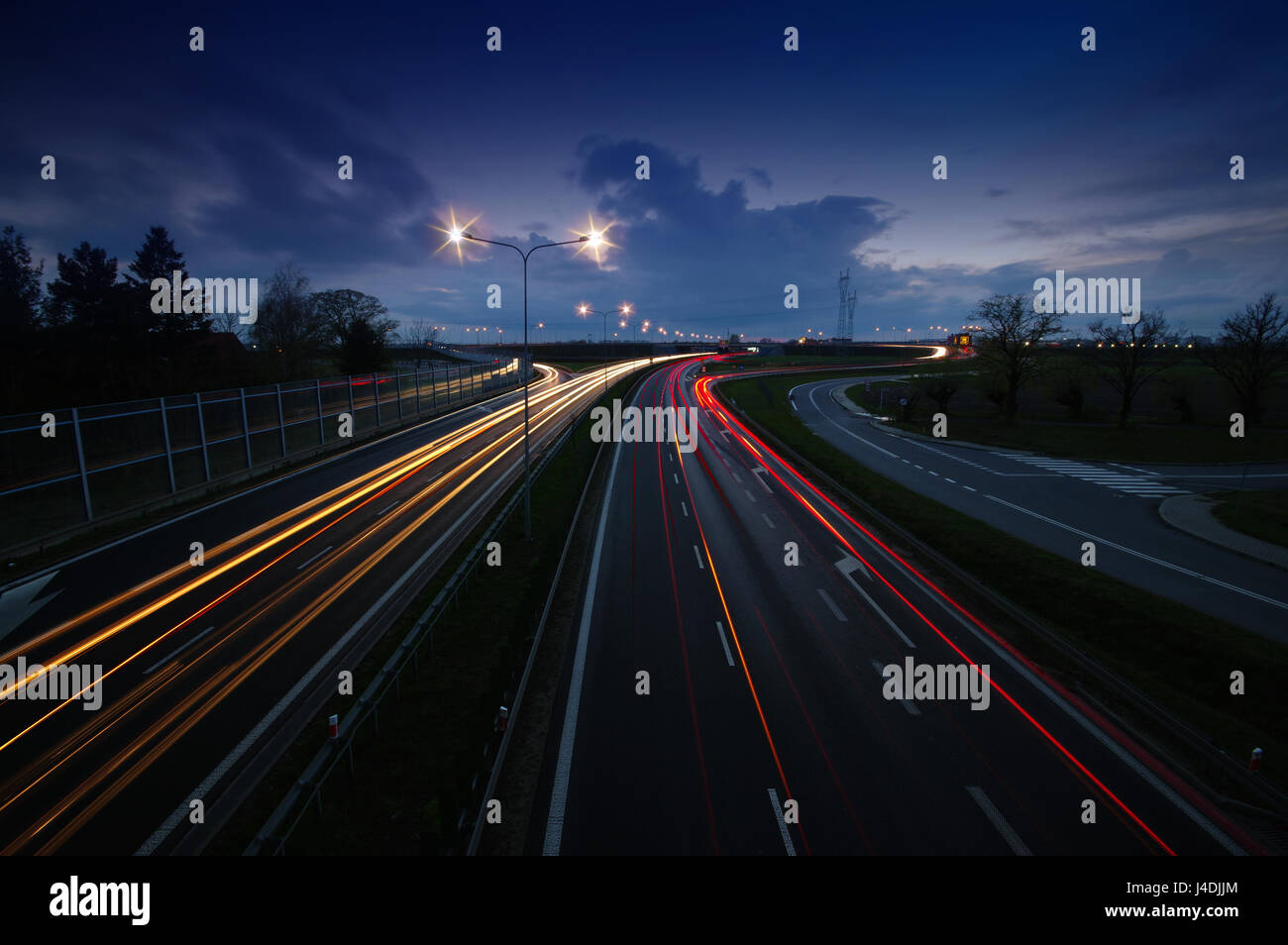 Autobahn-Verkehr mit Lichter Trails am Abendhimmel Stockfoto