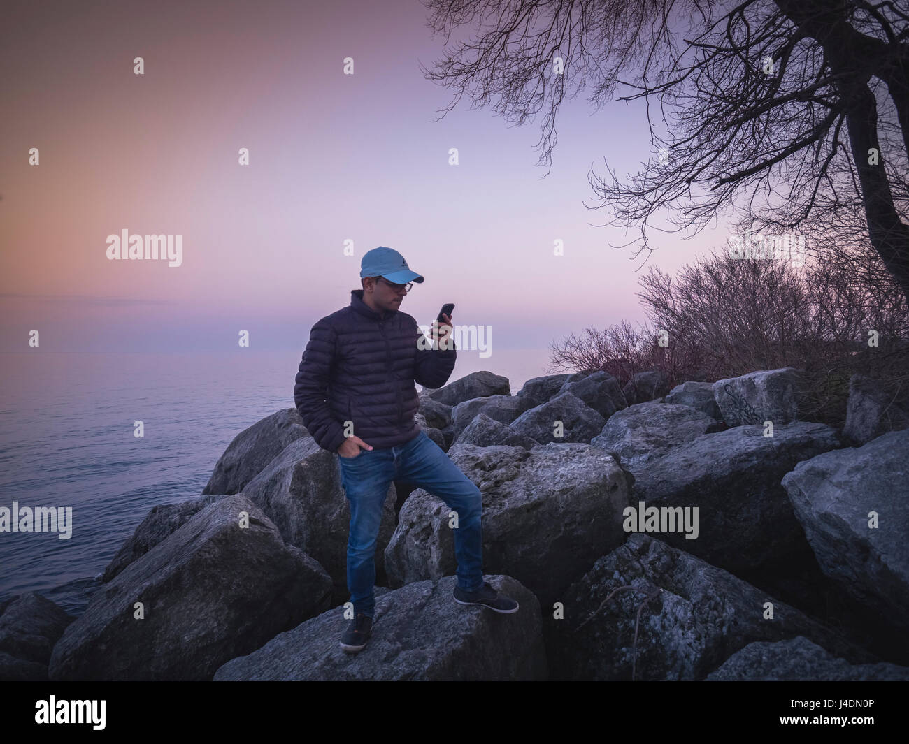Ein junger Mann Klick Bild bewundernden natürliche Schönheit von Humber Bay Lake Ontario, Toronto, Kanada Stockfoto