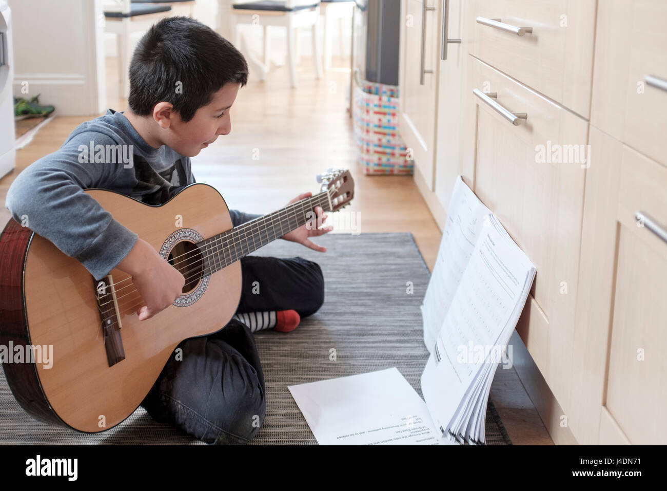 Junge spielt akustische Gitarre, UK Stockfoto