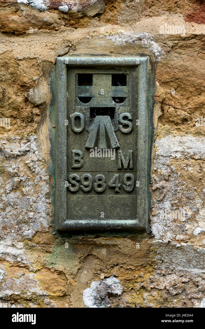 Ordnance Survey Benchmark auf eine Kirchenmauer, Northamptonshire, UK Stockfoto