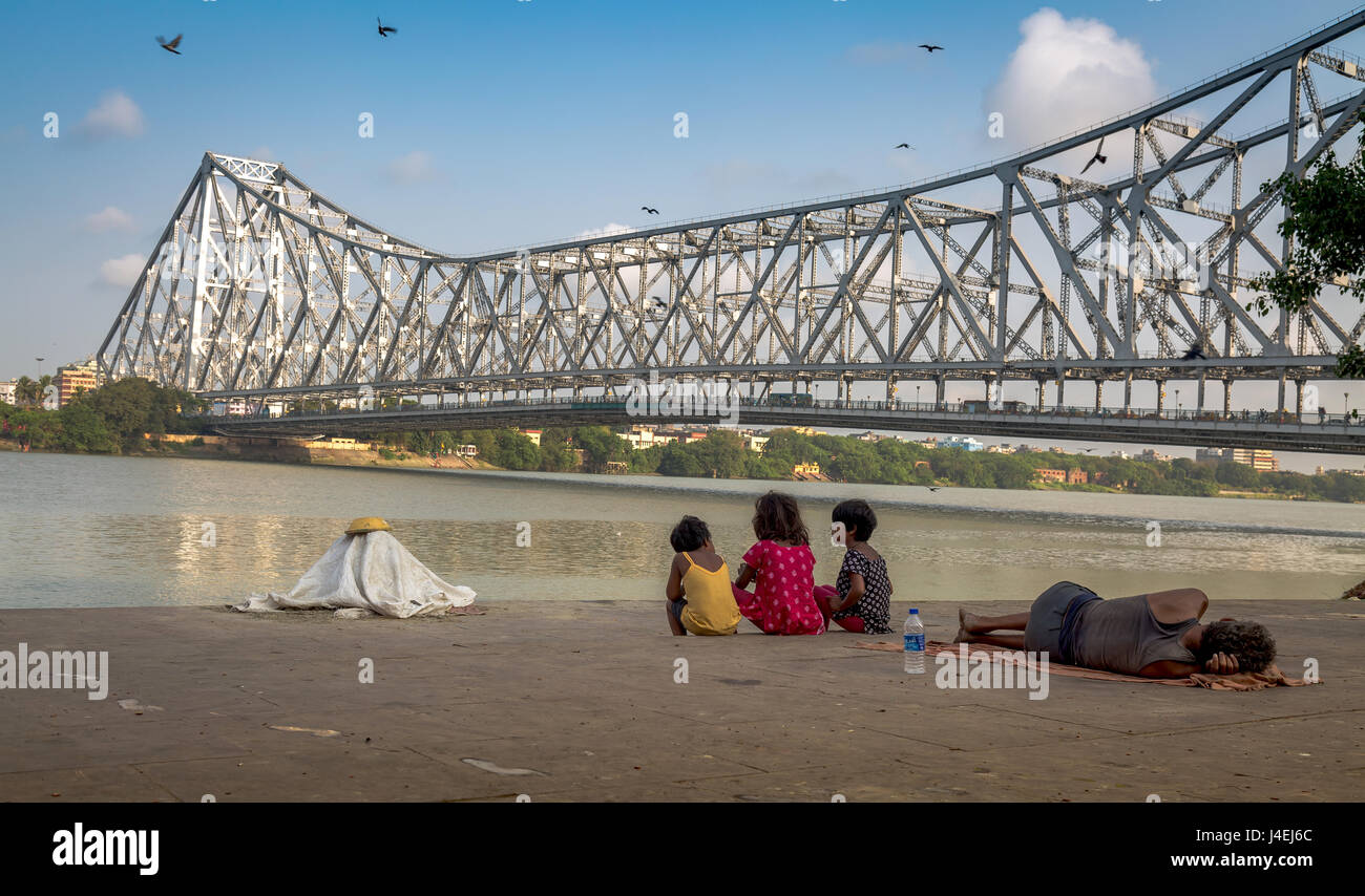 Street Kids genießen Sie den Blick auf das howrah Bridge aus dem hooghly River Bank mallick Ghat, Kolkata, Indien. Stockfoto
