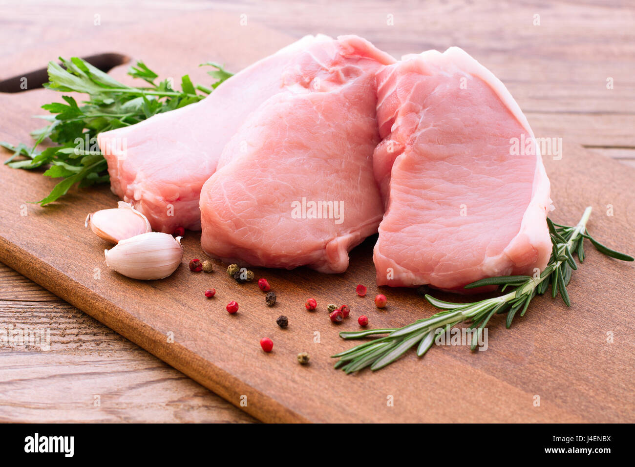Rohes Schweinefleisch auf Schreibtisch aus Holz Stockfoto