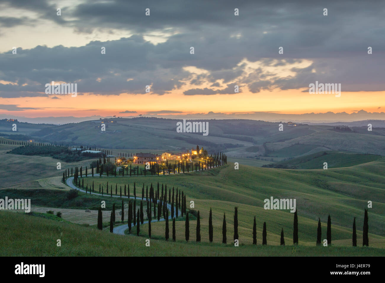 Sonnenuntergang auf grünen Hügeln, umgeben von Zypressen und Bauernhäuser, Crete Senesi (Senese Tonen), Provinz Siena, Toskana, Italien Stockfoto