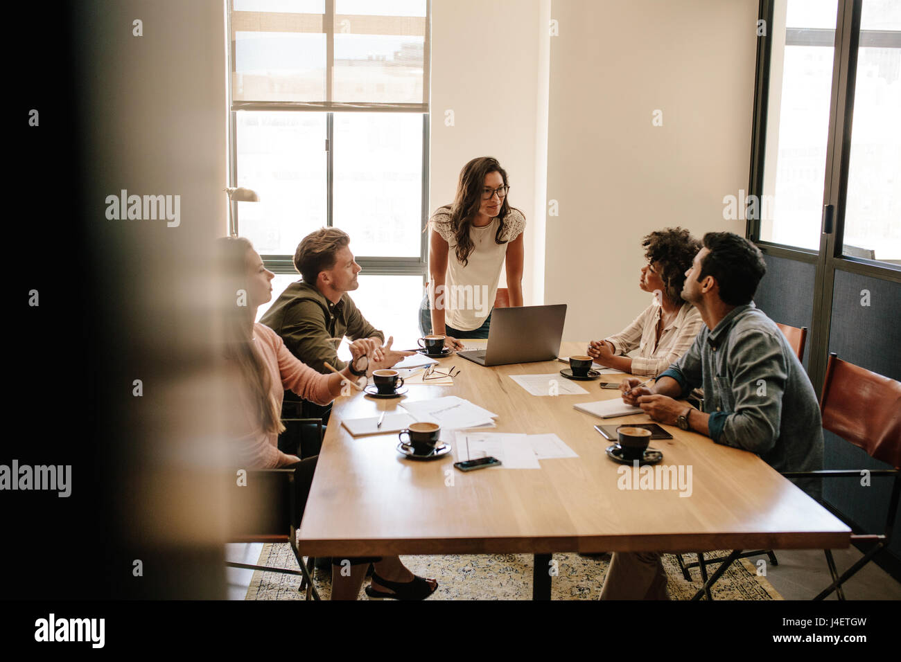 Schuss des Multi-ethnischen Geschäftsleute mit einem Treffen im Büro. Business-Team mit Frau Präsentation an einem Tisch sitzen. Stockfoto