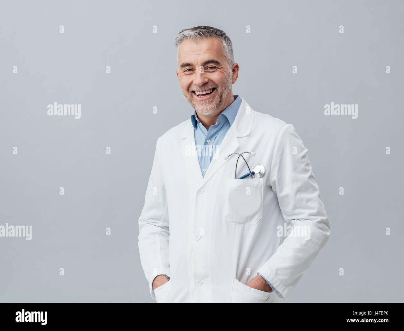 Fröhliche Reife Arzt posieren und lächelnd in die Kamera, Gesundheitswesen und Medizin Stockfoto