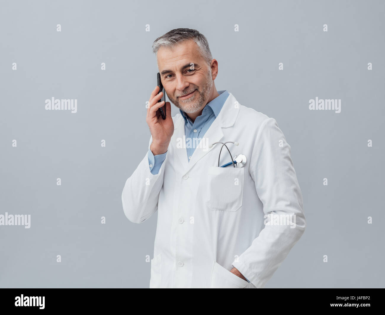 Zuversichtlich Reife Doktor mit einem Anruf mit seinem Smartphone: Sanitätsdienst Beratung per Telefon Stockfoto