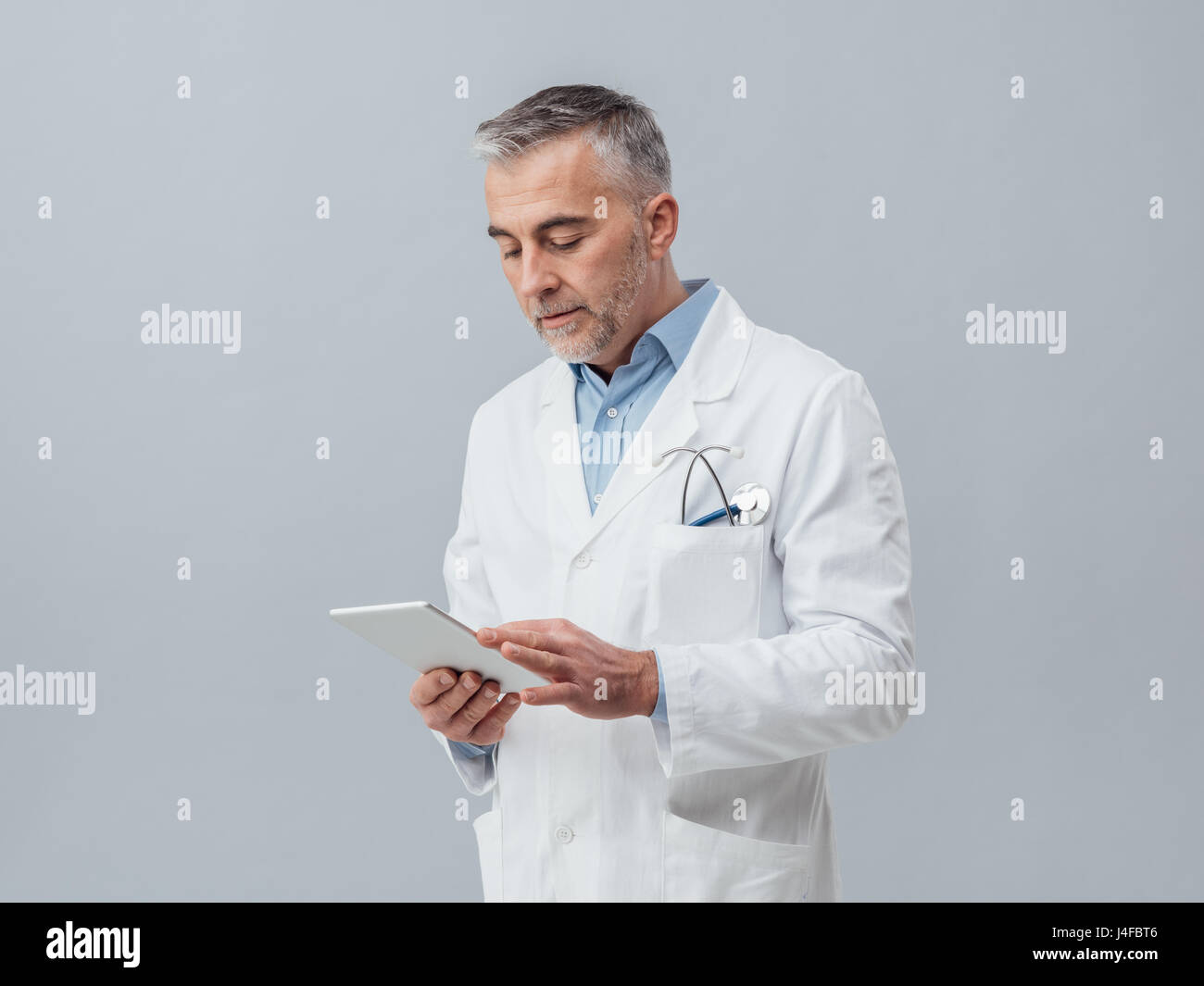 Zuversichtlich Reife Arzt Anschluss mit einem digital Touch-Screen-Tablette und mit apps, Online-medizinische Diagnose und Beratungskonzept Stockfoto