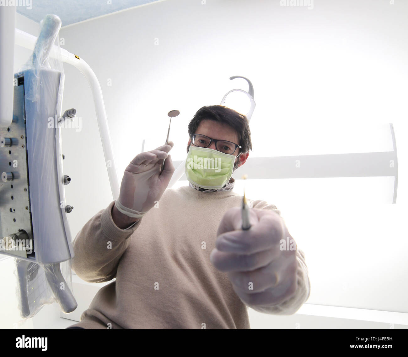 Arzt Klinik Zahnarzt mit grüne Maske und Werkzeuge für die Reinigung der Zähne Stockfoto Arzt Klinik Zahnarzt mit grüne Maske und Werkzeuge für die Reinigung der Zähne Stockfoto