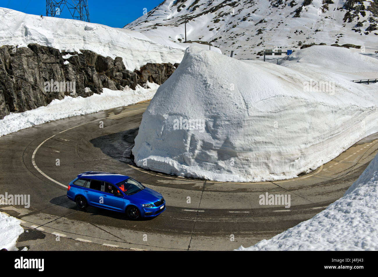 Haarnadelkurve um einen Haufen Schnee von der Passstrasse über den St. Gotthard Pass, St. Gotthard Pass, Kanton Tessin, Schweiz Stockfoto