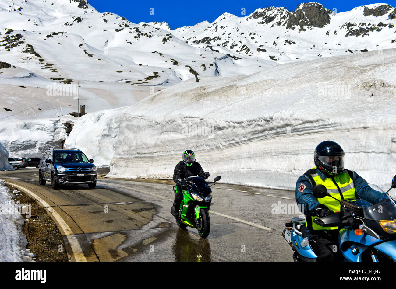 Zwei Motorradfahrer, die Überquerung der St. Gotthard-Pass auf der  Passstrasse zwischen hoher Schneewände, St. Gotthard-Pass, Airolo, Kanton  Tessin, Schweiz Stockfotografie - Alamy