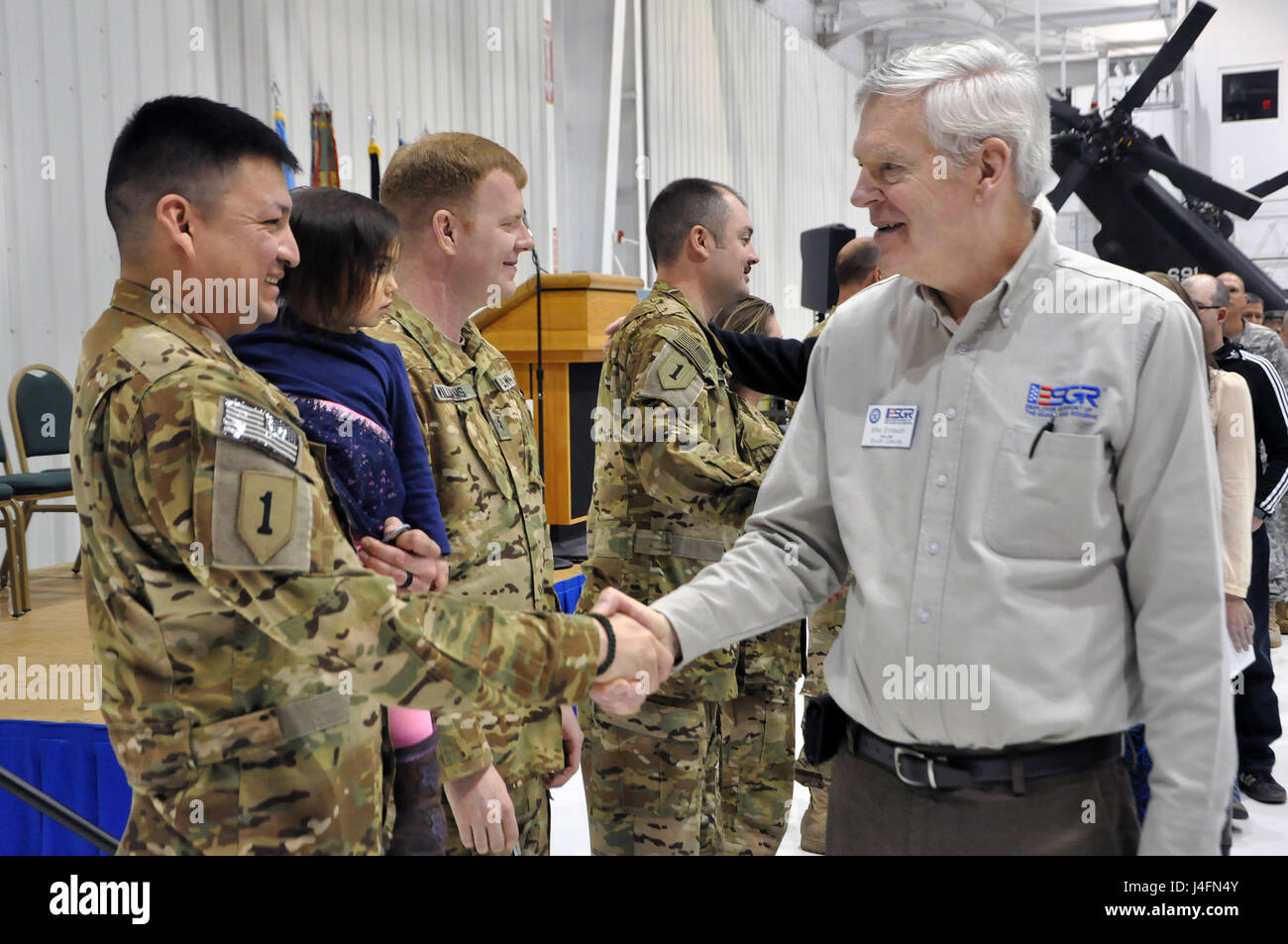 Hause begrüßt US Armee SGT Derek Lebeau, mit der South Dakota Army National Guard Ablösung 48, operative Unterstützung Luftbrücke Befehl, während das Gerät nach Hause Begrüßung bei der Army Aviation Support Facility, Rapid City, S.D., 23. Januar 2016 pensionierte Command Sergeant Major Mike Birnbaum. Die Luftfahrt-Einheit war acht Monate in Afghanistan zur Unterstützung der Operation Freedom Sentinel. Stockfoto