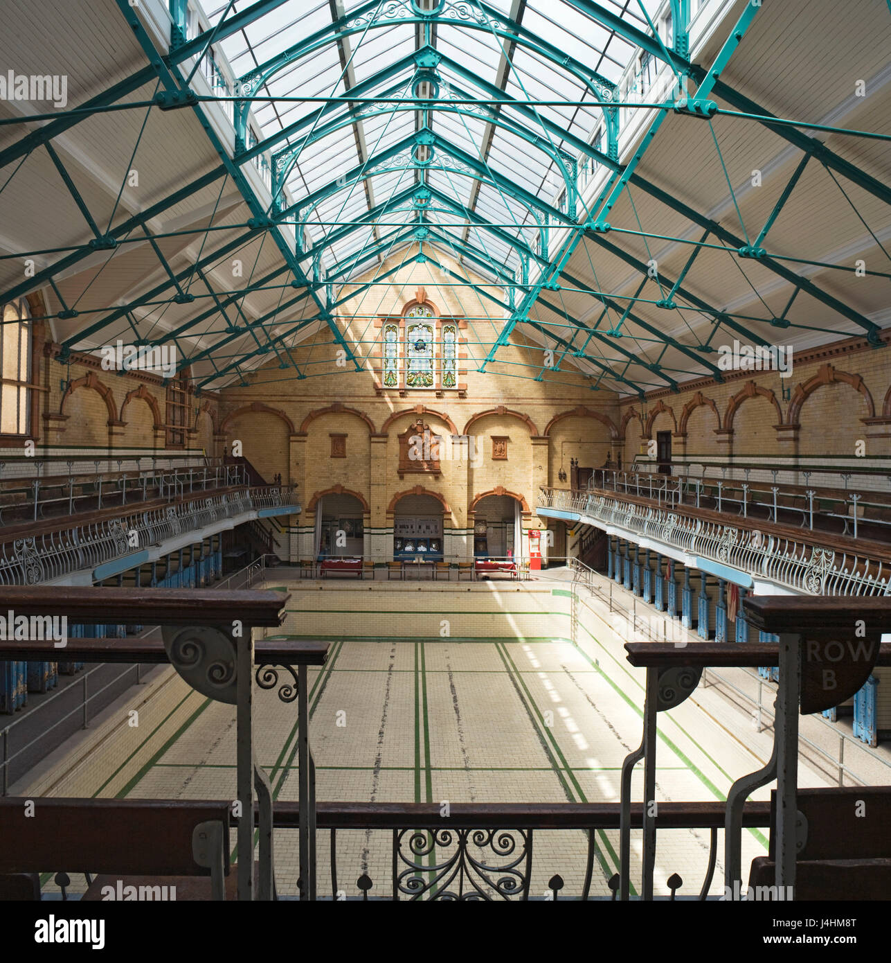 Erhöhte Sicht durch die Schwimmhalle mit Pool vor der Sanierung. Victoria-Bäder, Manchester, Vereinigtes Königreich. Architekt: Henry Preis, 1906. Stockfoto