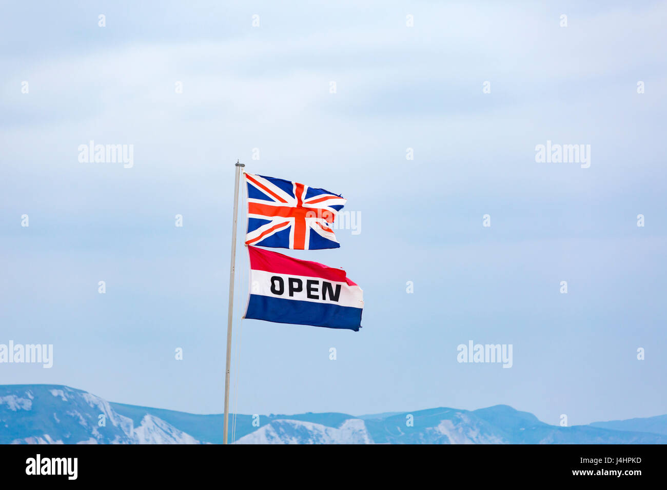 Union Jack-Flagge und offene Flaggen, die im Wind an der Küste in Weymouth, Dorset, UK, im Mai wehten - Konzept UK nach der Abstimmung ÜBER DEN BREXIT für Geschäfte geöffnet Stockfoto