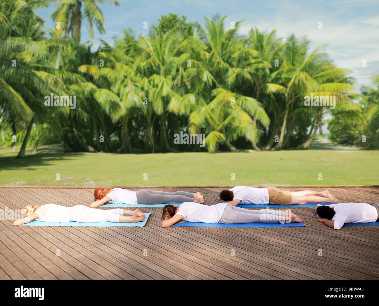 Gruppe von Menschen machen Yoga im Freien und Lügen Stockfoto