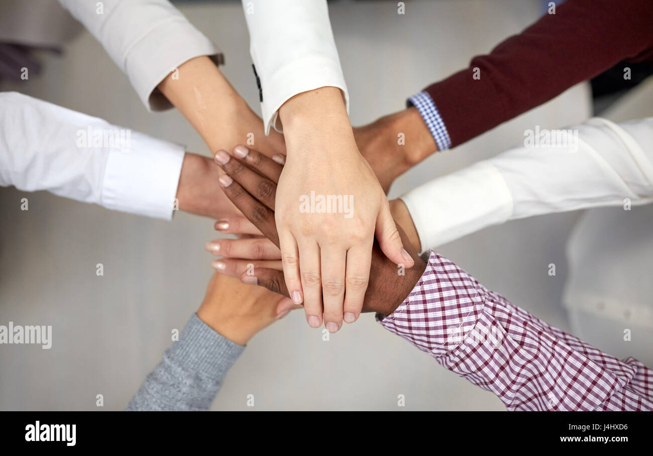 Business-Team mit Händen an der Spitze im Büro Stockfoto