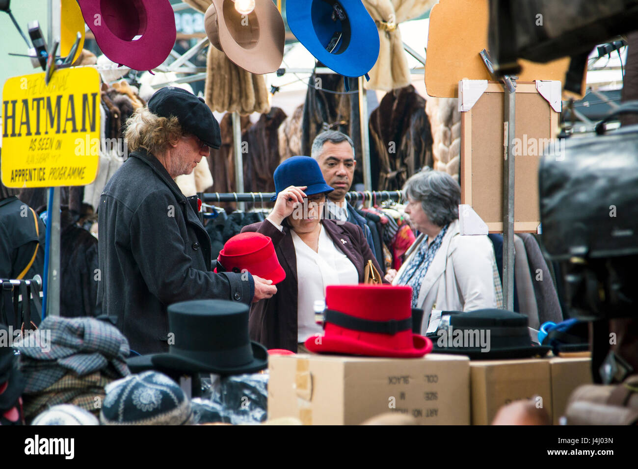 Paar versucht auf Hüte in Spitalfields Market, London, UK Stockfoto