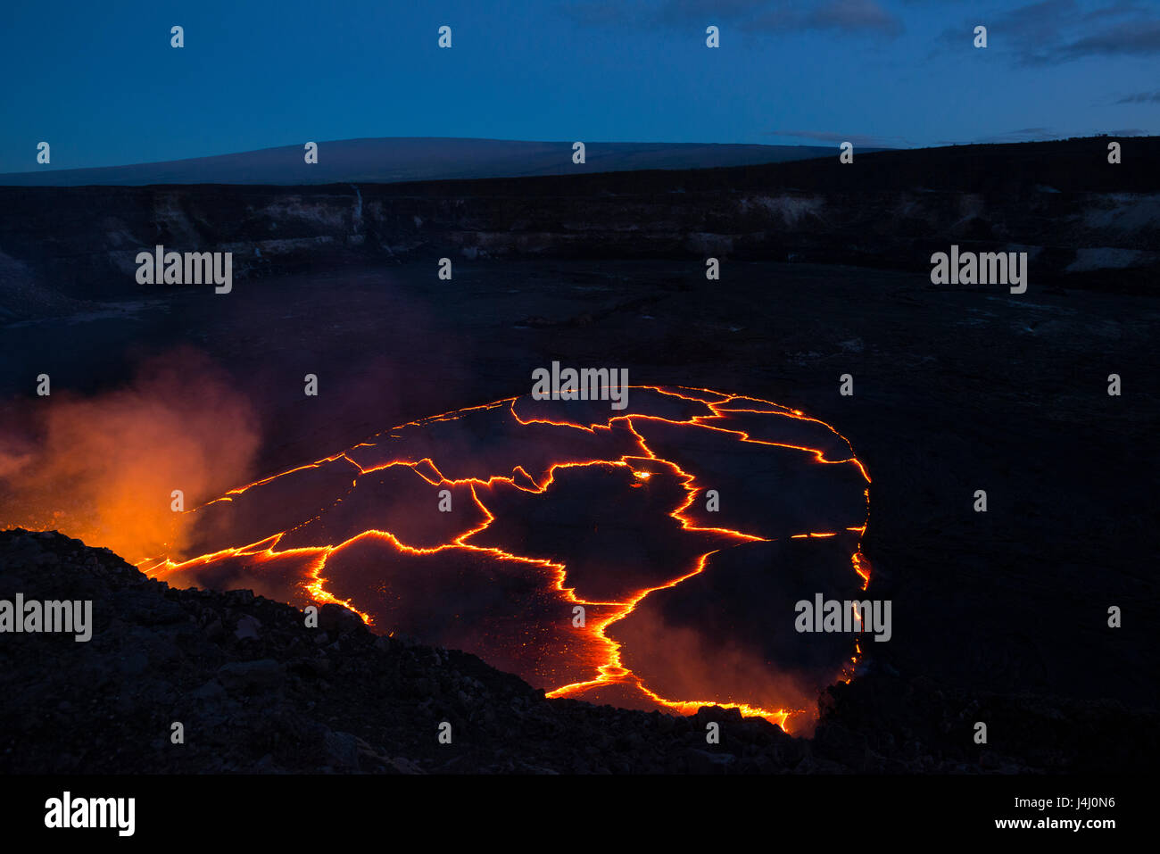 Lavasee in Caldera des Halemaumau Crater, Kilauea Vulkan, Hawaii, USA, mit Mauna Loa Berg im Hintergrund in vor Sonnenaufgang Stockfoto