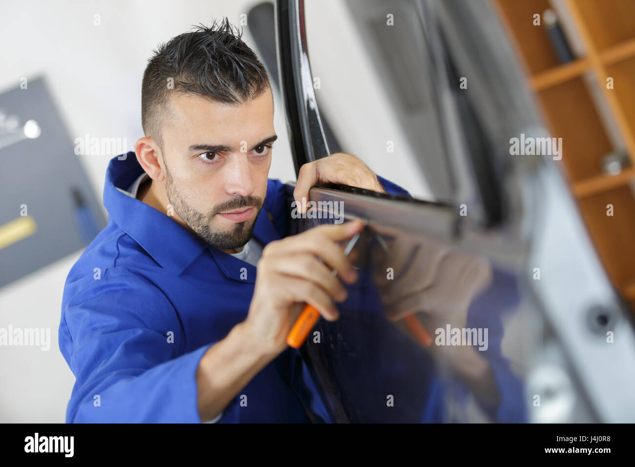 Mann mit Schraubenzieher Tür Kautschuk passt Stockfoto