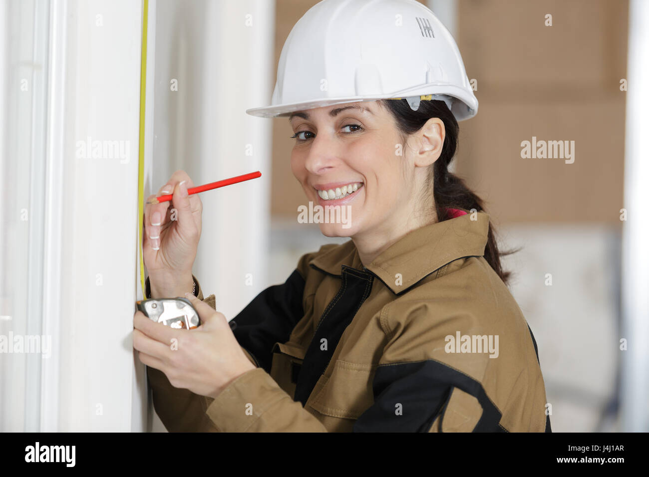 Erwachsene weibliche Konstruktor zeigt Assistent die Wand messen Stockfoto
