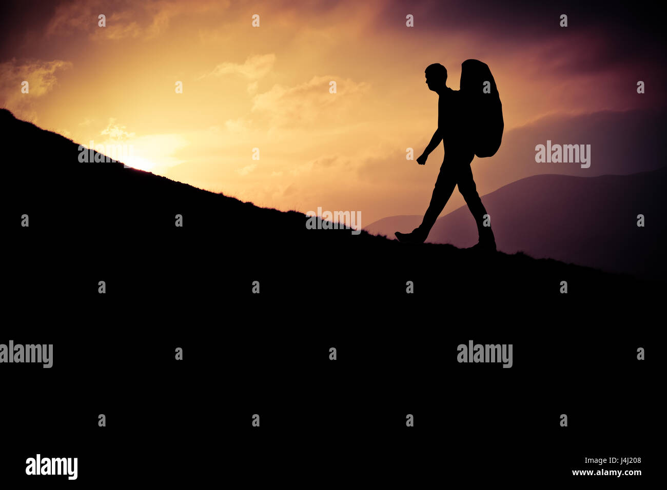 Retro Stil Design eines Silhouette jungen Mannes Wandern herauf einen steilen Hügel bei Sonnenuntergang Stockfoto