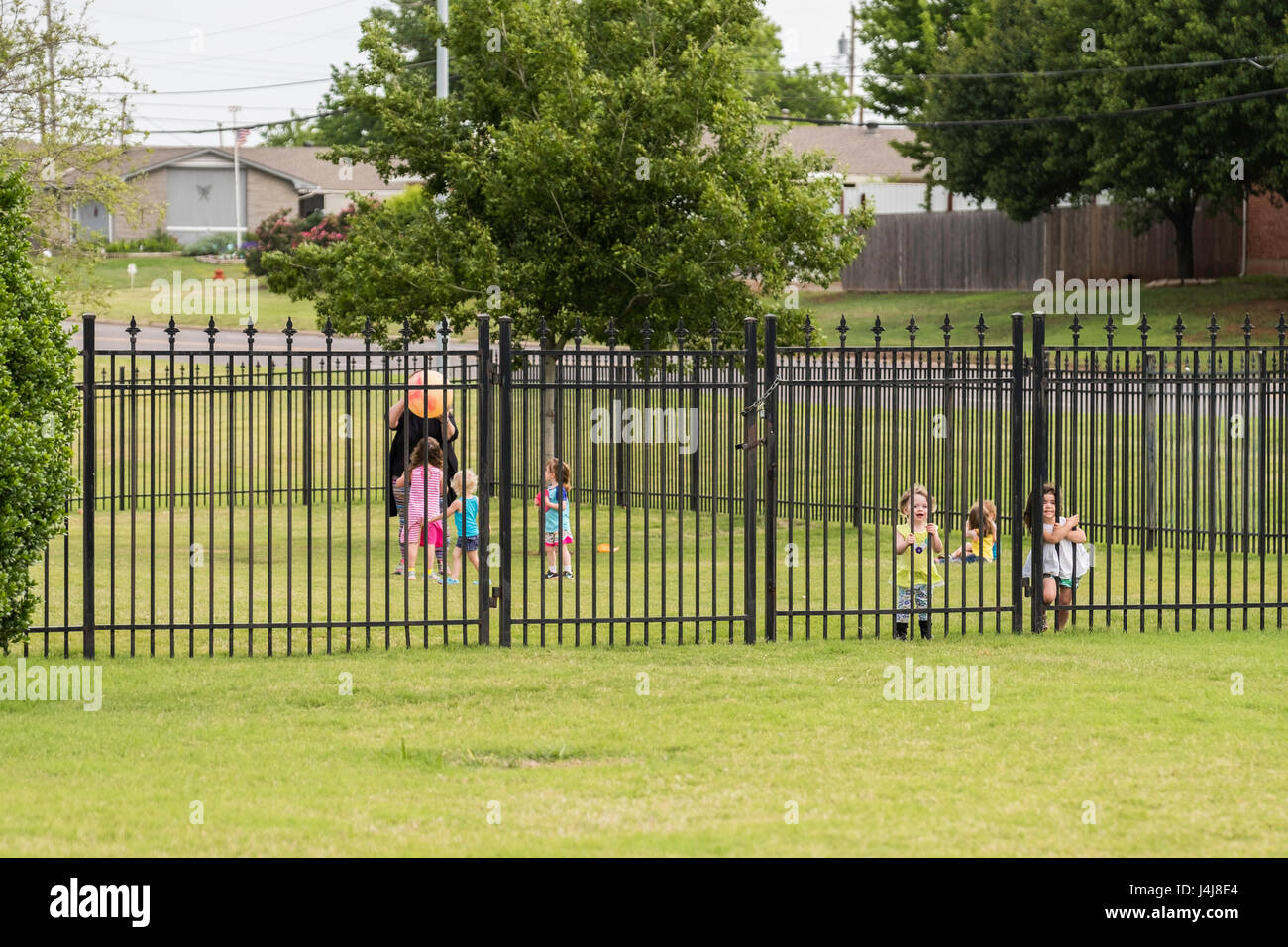 Kinder spielen im eingezäunten Bereich der Tagesstätte in Oklahoma City, Oklahoma, USA. Stockfoto
