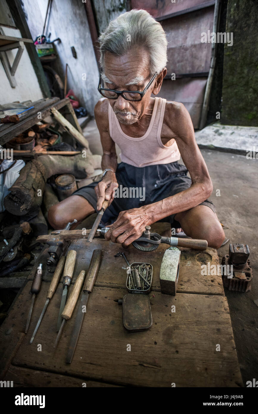 Senior-Zimmermann bei der Arbeit in seiner Werkstatt in Yogyakarta, Java, Indonesien. Stockfoto