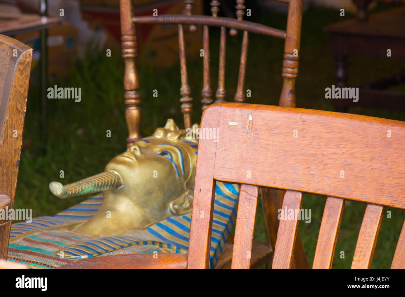 Tutanchamun-Maske beruht auf antike Stühle auf Flohmarkt. Stockfoto