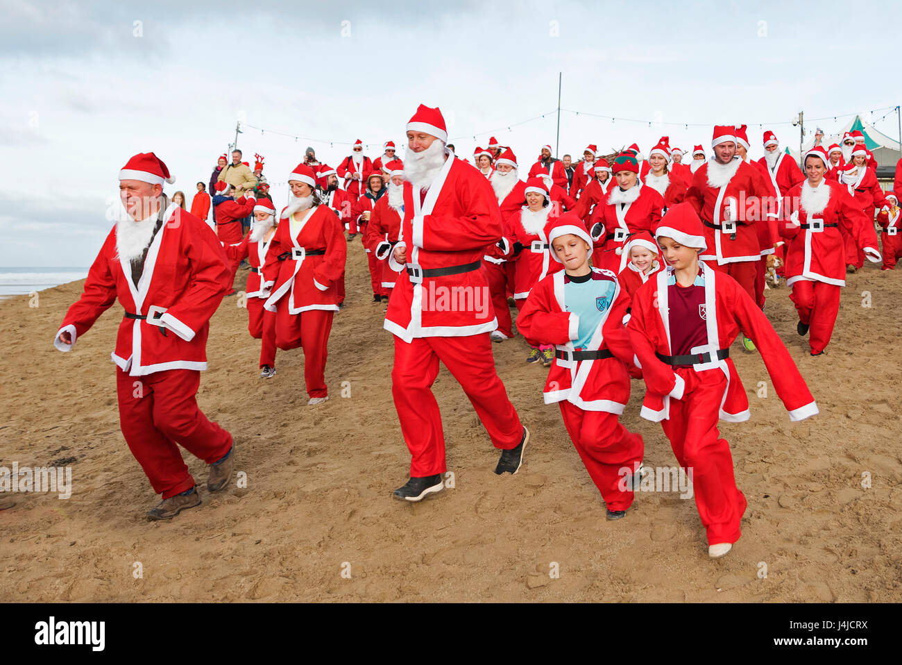 Perranporth, Cornwall, UK. 18. Dezember 2016. Santa auf dem Sand eine jährliche Charity laufen am Strand von Perranporth in Cornwall, Großbritannien Stockfoto