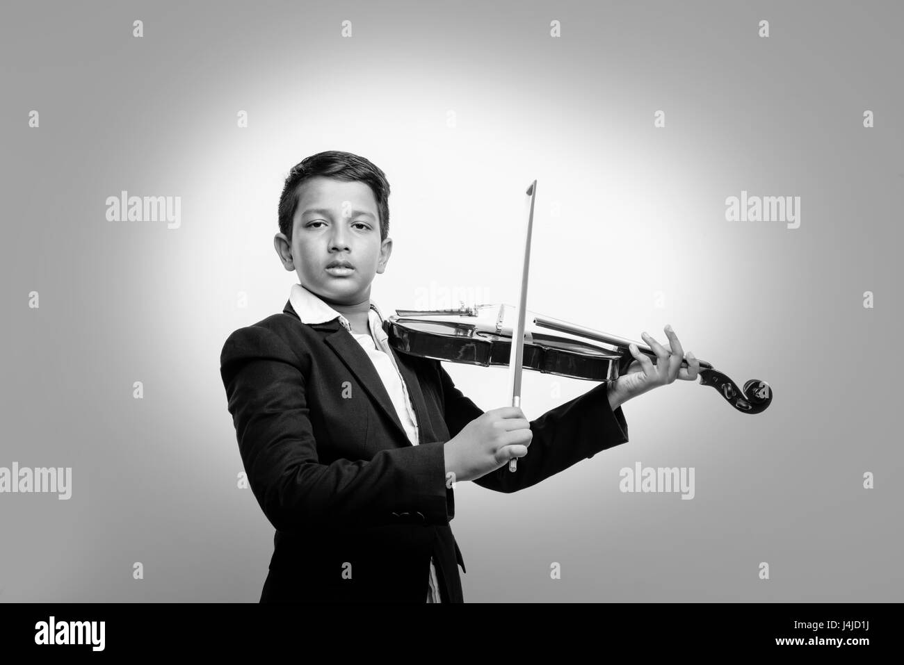 Niedliche kleine indische / asiatische junge spielen Geige wie ein Profi, isoliert über weißem Hintergrund Stockfoto