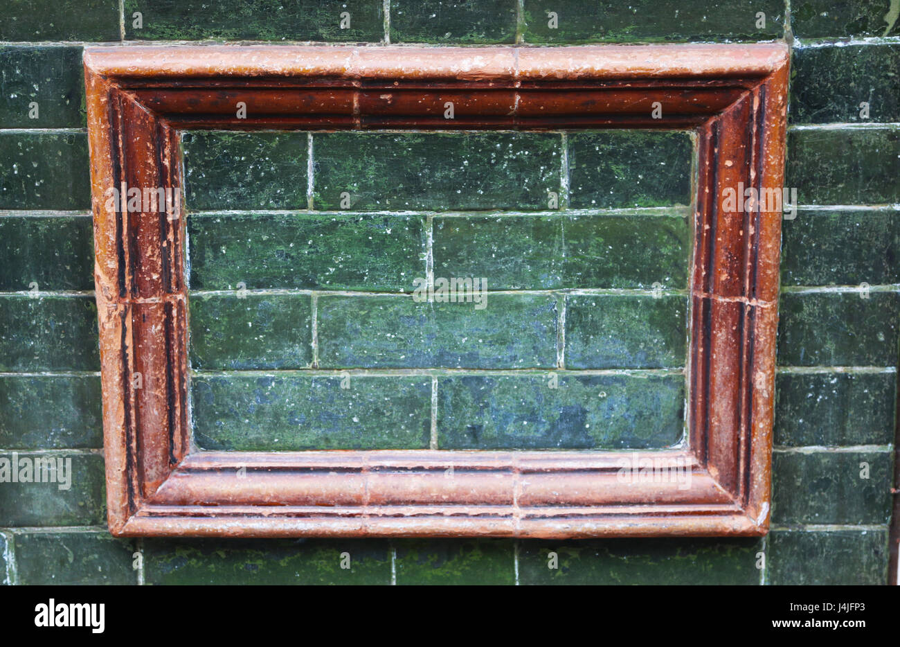 keramische Rahmen auf grünen Fliesen Wand Stockfoto