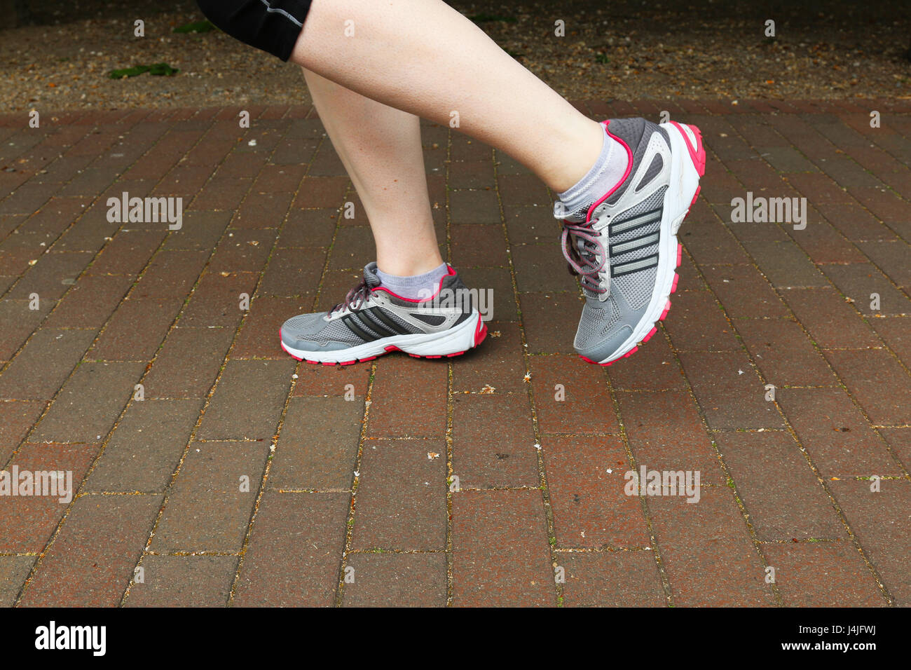 Füße in Laufschuhe/Trainer Stockfoto