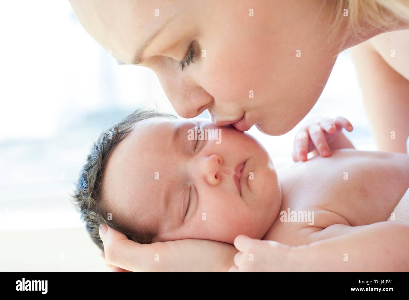 Mutter küssen neugeborenes Mädchen. Stockfoto