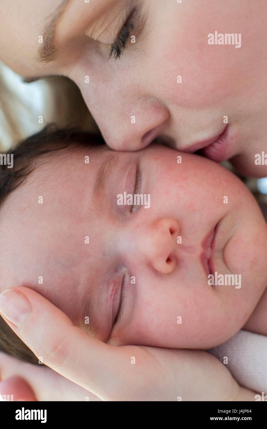Mutter küssen neugeborenes Mädchen. Stockfoto