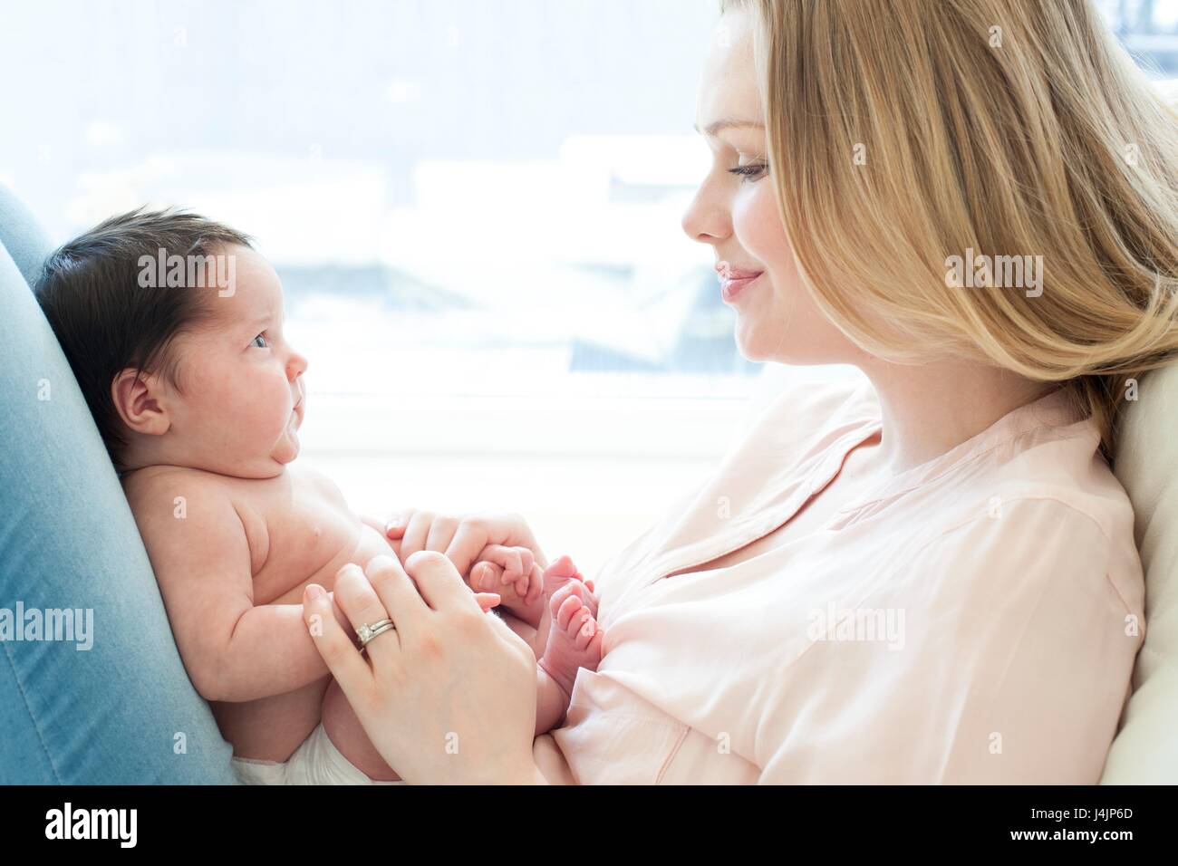 Neugeborenes Baby Mädchen sitzt auf dem Schoß der Mutter. Stockfoto