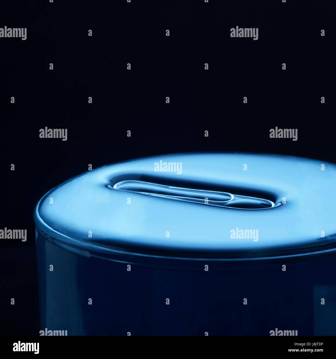 Büroklammer schwimmt auf Wasser in einem Glas, Studio gedreht. Stockfoto