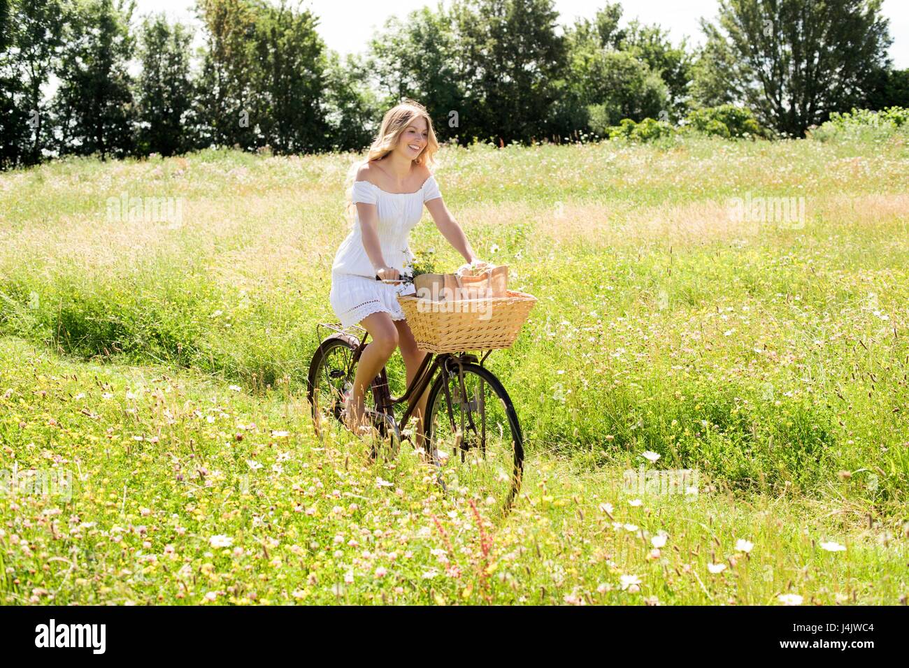 Junge Frau Reiten Fahrrad in das Feld ein. Stockfoto