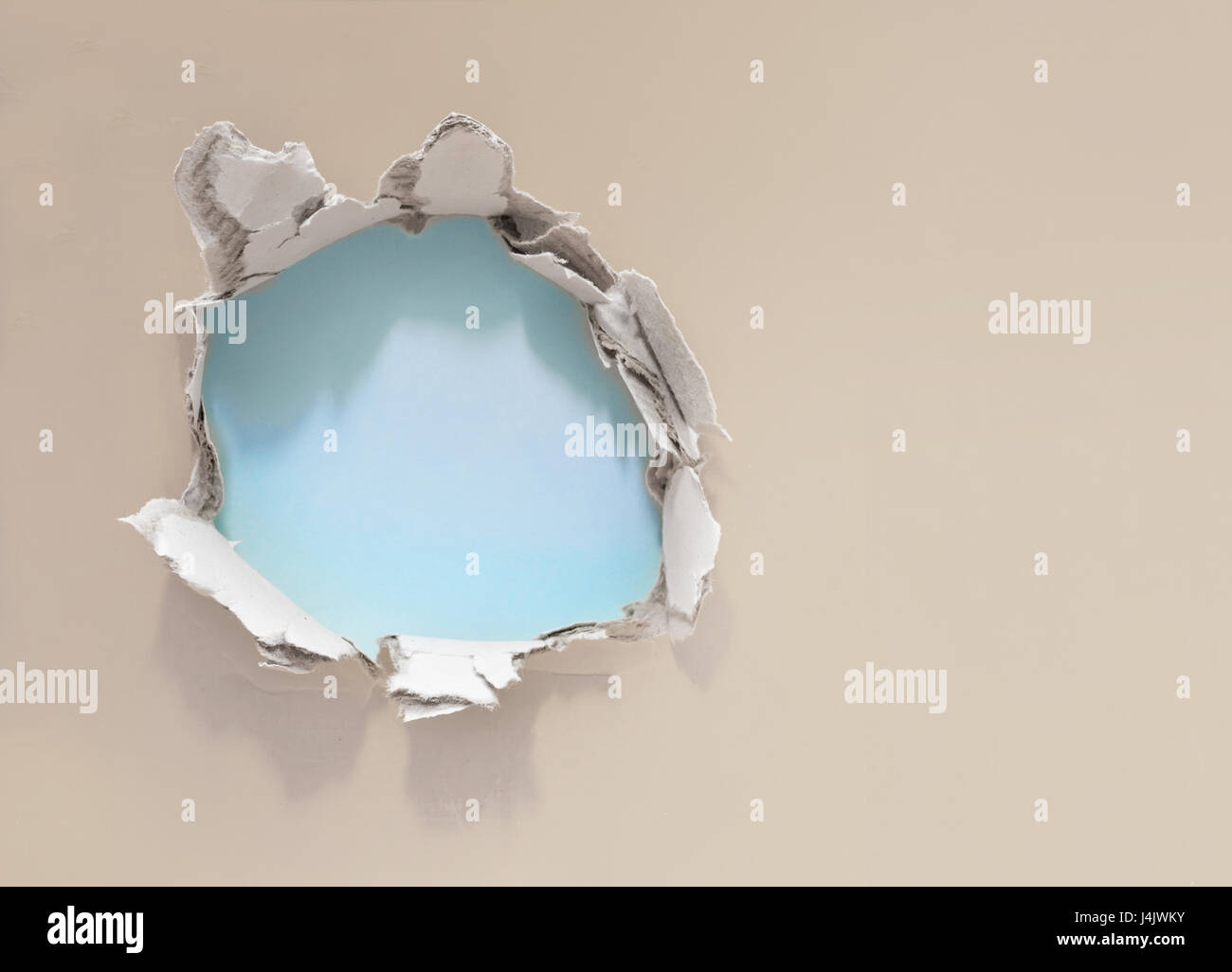 Loch im Papier Wand Stockfoto