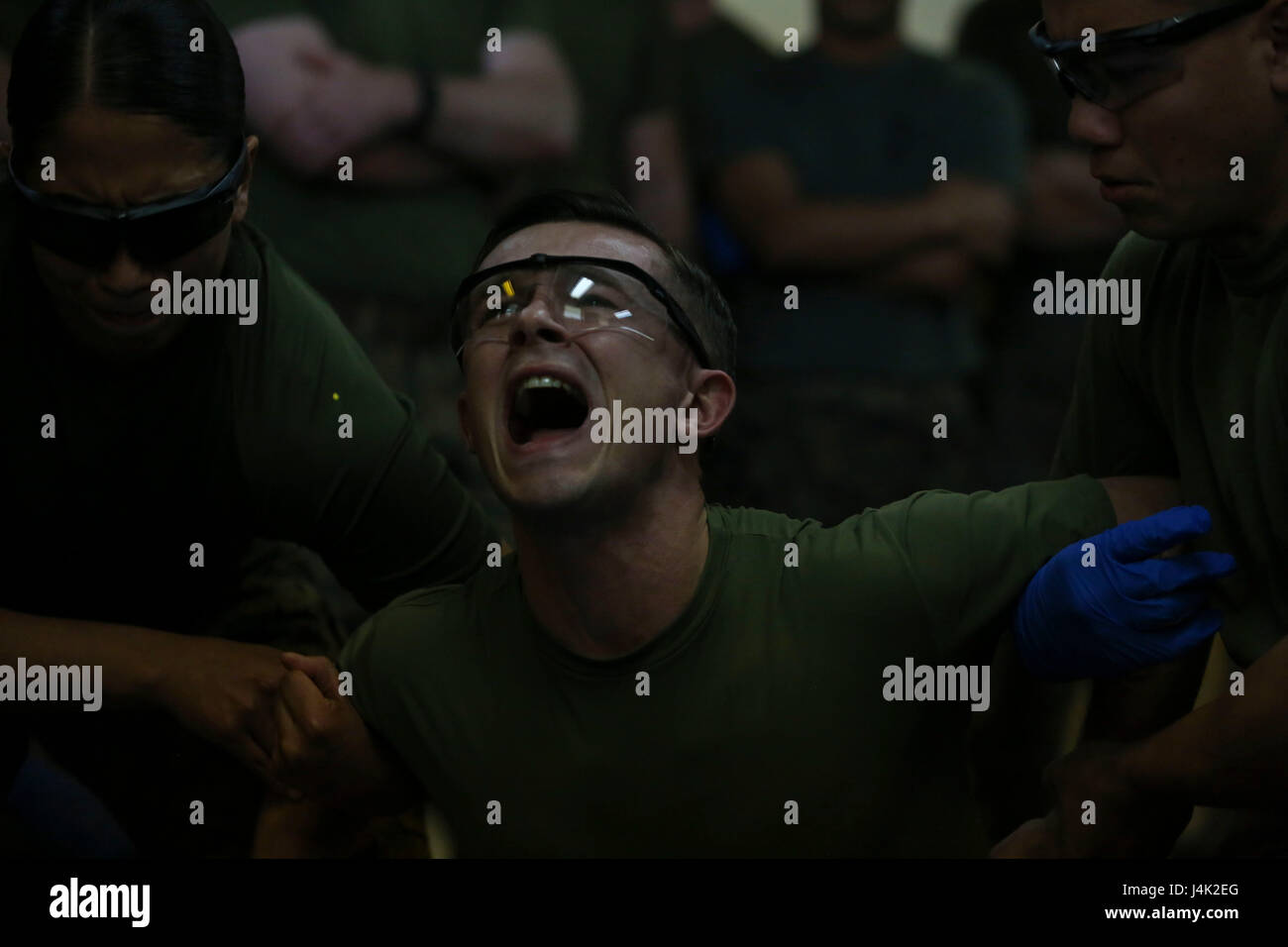 US Marine Corps 2nd Lt. Michael Enomoto, Militärpolizei, Zeitformen und Schreie, nachdem er mit Taser Widerhaken geschlagen, als Teil der nicht-tödliche Instructor Kurs auf Lager Hansen, Okinawa, Japan Waffen. Marines, Matrosen, Piloten und japanischen Wachpersonal füllen Sie eine Woche lang nichttödliche Instructor Kurs Waffen welche überdachte Taser Training, OC Belichtung und Riot Teamtaktik steuern. (Foto: U.S. Marine Corps MCIPAC Bekämpfung der Kamera Lance Cpl. Brooke Deiters) Stockfoto